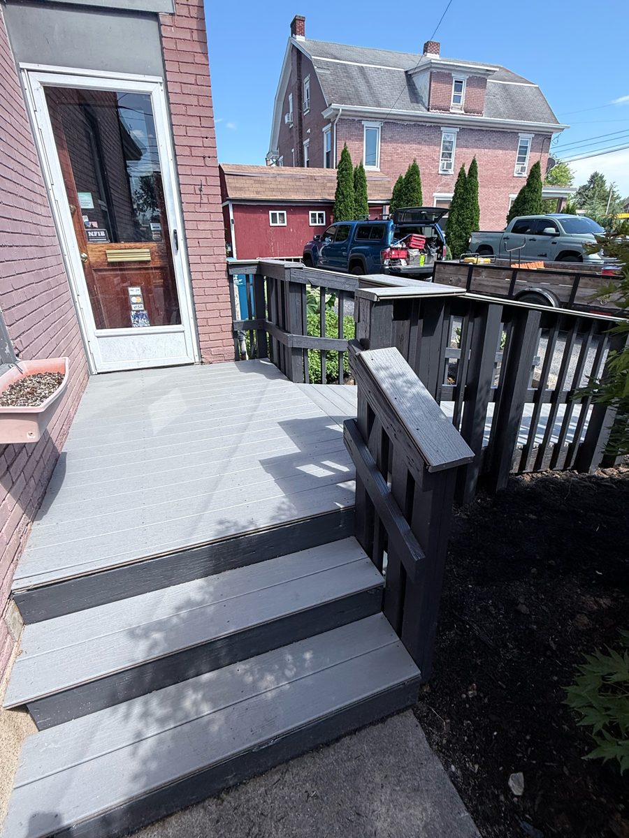 Same stoop and two steps after: gray Trex composite decking, new posts and dark gray rails